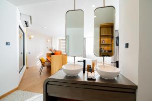 岘港PĀMA Boutique Hotel & Bistro的浴室设有2个水槽和1个带镜子的台面