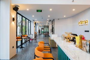 岘港PĀMA Boutique Hotel & Bistro的餐厅里的酒吧,带橙色椅子