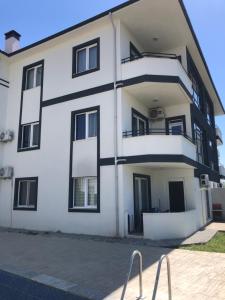 达拉曼Dalaman Apart Vacance , Ozgün Deniz Sitesi No 5的白色的公寓楼,设有黑窗