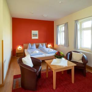 Creuzburg斯提夫沃尔姆生态酒店的一间卧室配有一张床、两把椅子和一张桌子
