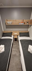 耶泽拉Mobile Homes Albatross的客房设有两张床、一张桌子和书架。