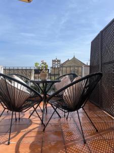 科尔多瓦圣费尔南多76号公寓的阳台的天井配有桌椅