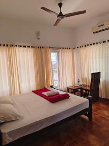 PallipuramTimber Monk Beach Resort的一间卧室配有一张大床和吊扇