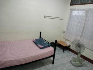 北碧迦南酒店的卧室配有1张床、风扇和桌子