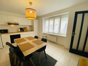 特里尼亚克Appartement Confortable - Trignac Centre Ville的厨房以及带桌椅的用餐室。