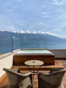 利莫内-苏尔加达Residence Dalco Suites & Apartments的阳台配有桌子和两把椅子,享有山景。