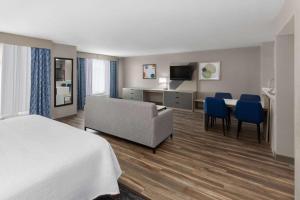 萨尔弗Wingate by Wyndham Sulphur Near Lake Charles的酒店客房配有一张床、一张沙发和一张书桌。