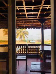 PallipuramTimber Monk Beach Resort的享有带长椅和棕榈树的门廊的景色