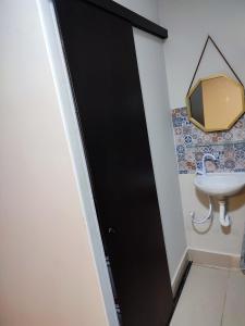 里贝朗普雷托Kitnet na melhor localização JD Paulistano的一个带水槽的浴室内的黑色门