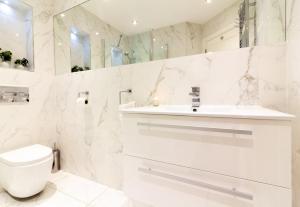 马拉海德GuestReady - Impressionante 2BR Flat com Vista Terraço e Mar的白色的浴室设有卫生间和水槽。