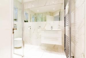 马拉海德GuestReady - Impressionante 2BR Flat com Vista Terraço e Mar的白色的浴室设有水槽和卫生间。