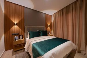 马拉喀什Appart Hôtel Rambla的一间卧室配有一张带绿色枕头的大床