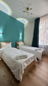阿拉木图Отель ЭРА的一间卧室设有两张床和蓝色的墙壁