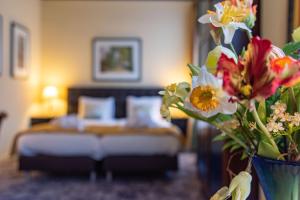 代尔登凯尔诗文兰谷德酒店的一间卧室,配有一张床和花瓶