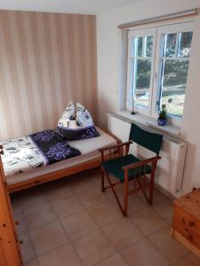 富伦多夫Ferienwohnung Waldblick的卧室配有床、椅子和窗户。