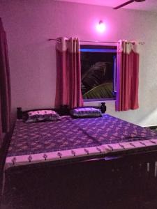 KumtaVT beach home leaf的紫色卧室,配有一张带紫色窗帘的床