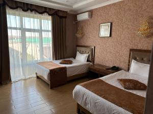 阿克托比Royal的酒店客房设有两张床和窗户。