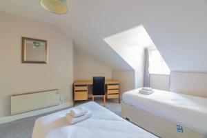 都柏林GuestReady - Castle Proximity and Modern Charm的一间卧室配有两张床和一张桌子及椅子
