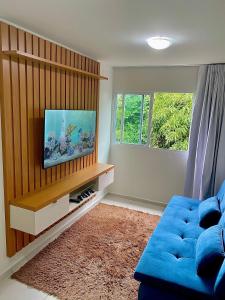 加拉尼温斯Apartamento Lótus Ar Cond Pertinho FIG e Centro的客厅配有蓝色的沙发和电视