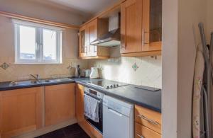 都柏林GuestReady - Castle Proximity and Modern Charm的厨房配有木制橱柜和白色洗碗机。