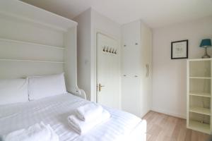 都柏林GuestReady - Coastal Charm near Sandymount Beach的卧室配有白色的床和2条毛巾