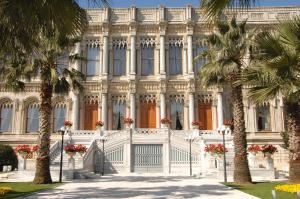 伊斯坦布尔伊斯坦布尔塞拉宫凯宾斯基酒店的一座白色的建筑,前面有棕榈树