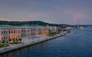 伊斯坦布尔伊斯坦布尔塞拉宫凯宾斯基酒店的一座大建筑,靠近水边,有一座桥