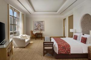 多哈珍珠马尔萨马拉兹凯宾斯基酒店的酒店客房带一张大床和一把椅子