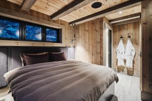 斯特兰达Chalet Strandafjellet的木墙和窗户的客房内的一张床位