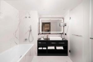 布达佩斯布达佩斯科维努斯凯宾斯基酒店的一间带水槽、浴缸和镜子的浴室