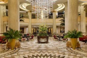 开罗开罗凯宾斯基御美心皇宫酒店的大堂设有吊灯和桌椅