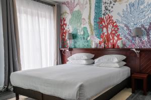 圣马洛维尔弗洛姆伊酒店的一间卧室设有一张带花卉墙壁的大床