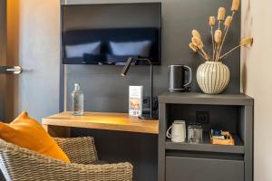 博尔库姆Arthotel Bakker的客房设有一张带电视和台灯的书桌。