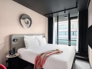布达佩斯TRIBE Budapest Stadium的酒店客房配有白色的床和镜子