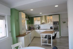 阿桂拉斯Casa La Vuelta的厨房拥有绿色和白色的墙壁,配有桌子