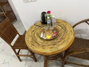 白马市El Ling guesthouse的圆藤桌,带两把椅子和一张桌子