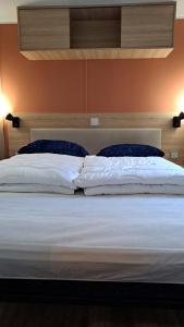 劳雷尔苏格Chalet Trigano的一张带白色床单和蓝色枕头的床