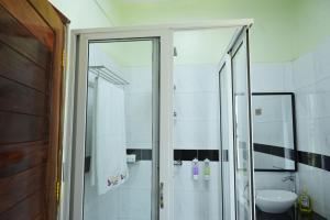YumbeESCAPE VILLAGE HOTEL的带淋浴和盥洗盆的浴室