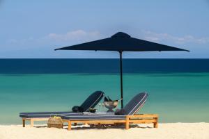 欧拉努波利斯Avaton Luxury Beach Resort - Relais & Chateaux的海滩上带遮阳伞和椅子的海滩