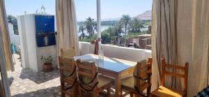 卢克索Abo Hisham Nile Flat的阳台配有桌椅,享有水景