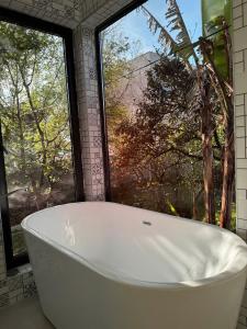 巴统Orion Cottage的带浴缸的浴室和大窗户