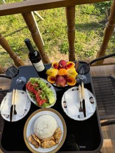 巴统Orion Cottage的餐桌,带食物盘和一瓶葡萄酒