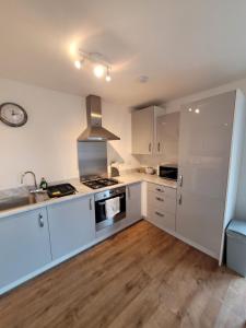 PeacehavenSkylark Apartment的厨房配有白色橱柜和炉灶烤箱。