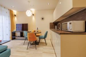 斯普利特Perimar Luxury Apartments and Rooms Split Center的厨房以及带桌椅的起居室。