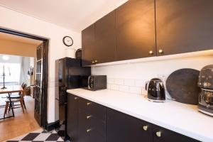 利物浦GuestReady - Walton's Delight的厨房配有黑色橱柜和黑色冰箱。