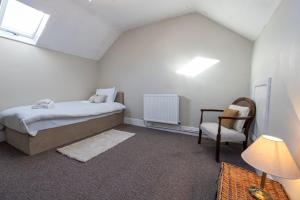 利物浦GuestReady - Walton's Delight的一间卧室配有一张床和一把椅子