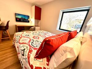 阿威罗RIACENTRUM - Smart Residence的一间卧室配有一张带红色枕头的床和一扇窗户