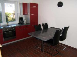 霍鲁梅尔希尔"Friesenhörn" 31 Merchant的厨房配有红色橱柜和桌椅