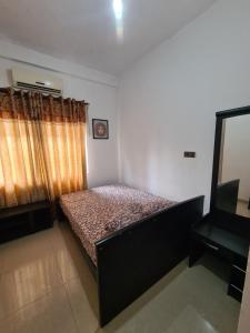 AmbanpolaHotel Mihira Village的一间小卧室,配有一张床和电视