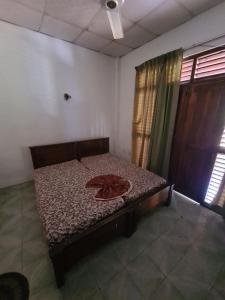 AmbanpolaHotel Mihira Village的一张小床,位于带窗帘的房间